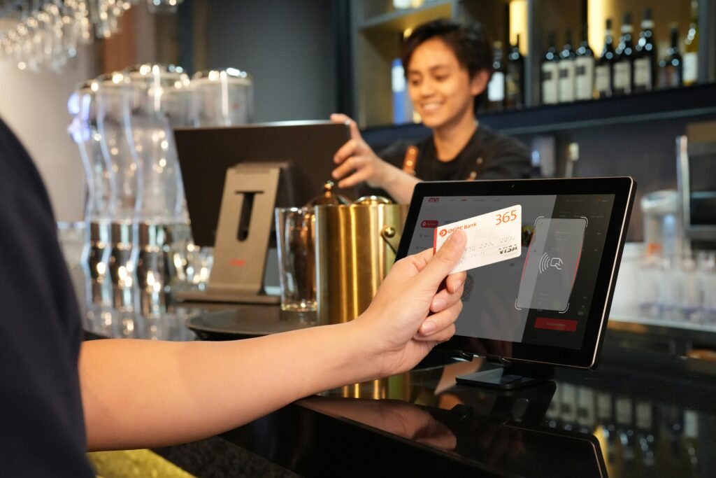 Cashier accepting payments in-person through a POS system
