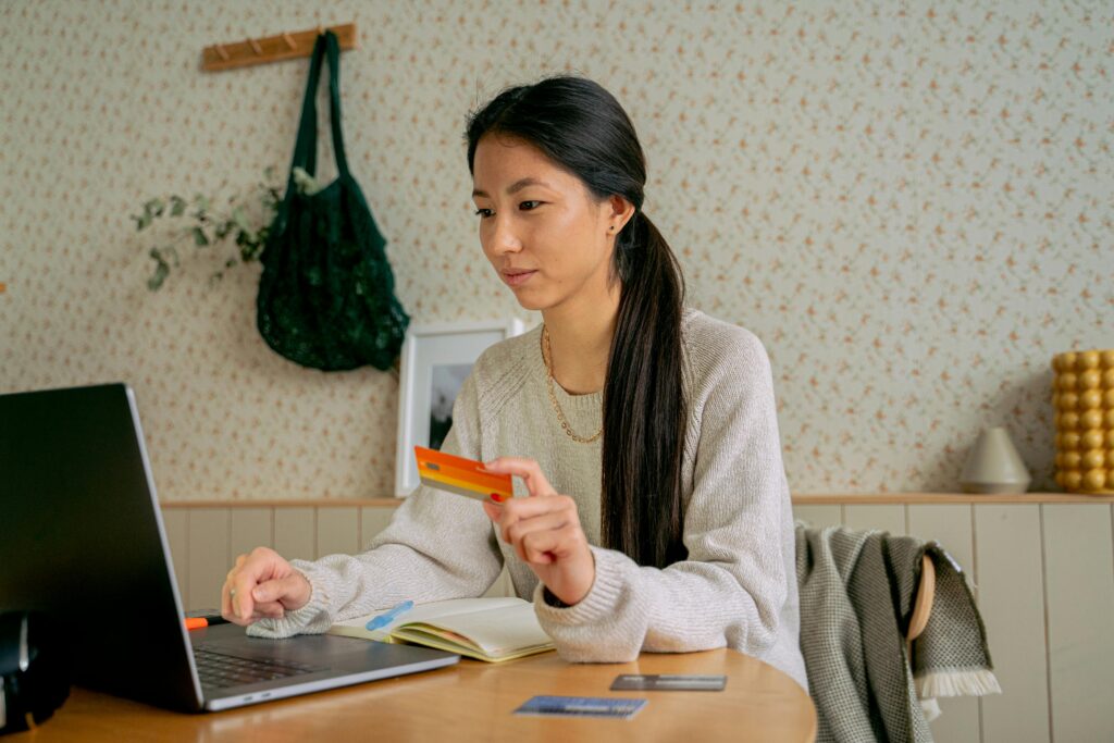 Woman holding a credit card while processing payment in QuickBooks