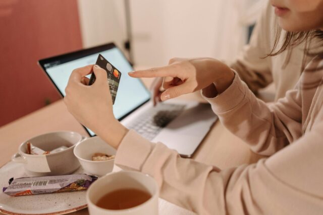 Credit card being shown in front of a laptop