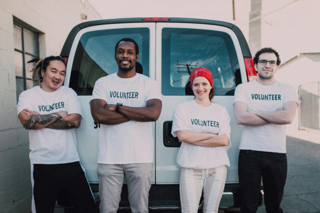 Nonprofit volunteers smiling at the back of a van