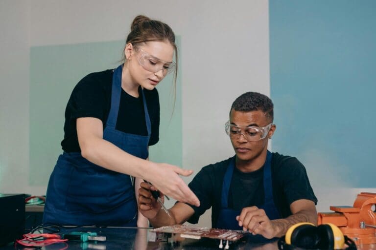 Two crew members working on manufacturing electronics