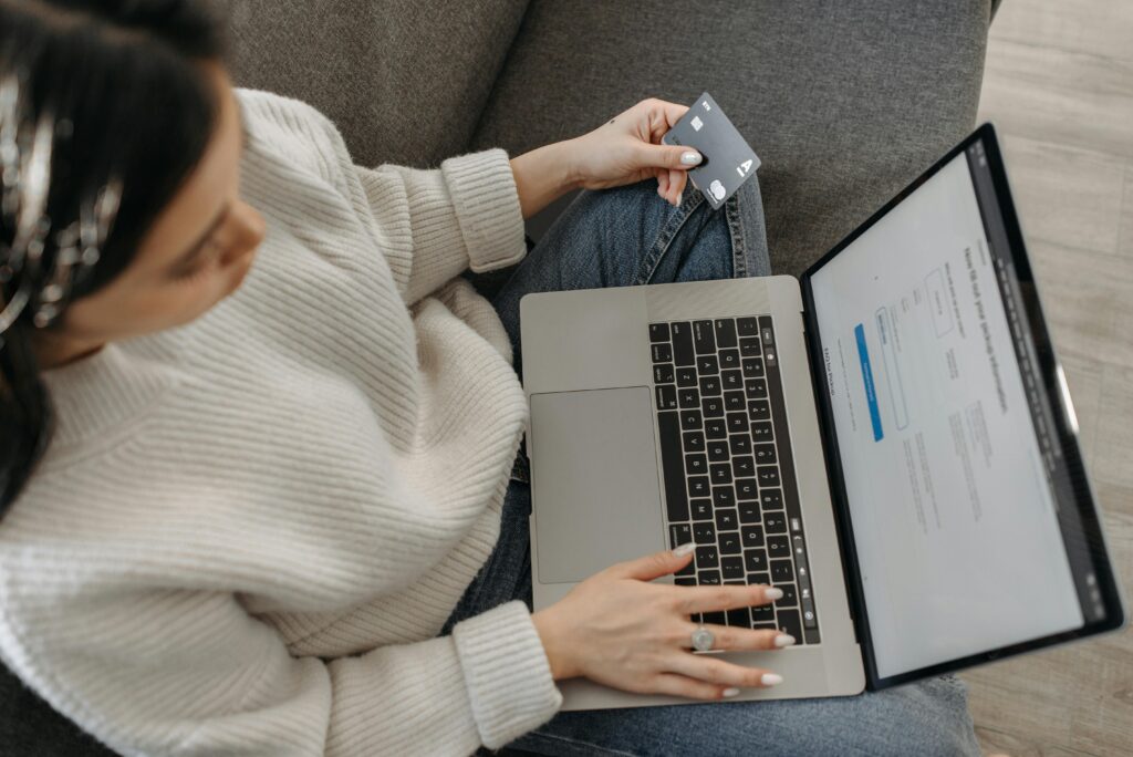 Woman holding a credit card while checking something on her laptop
