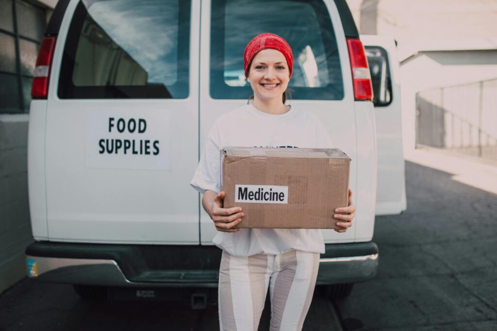 A nonprofit volunteer holding a medicine box