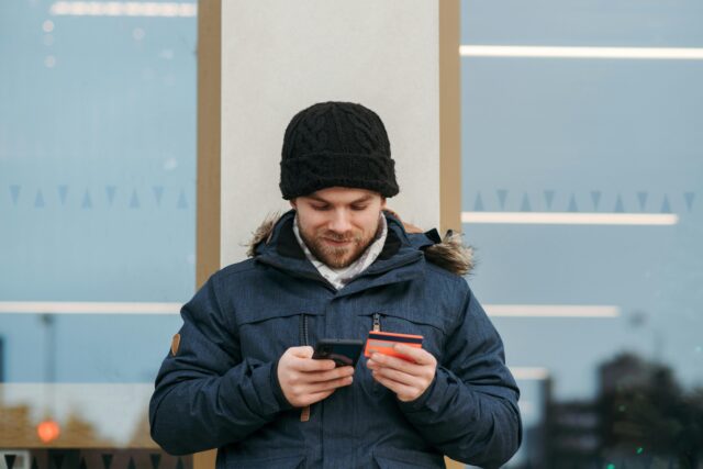 Man delightedly checking payments on his mobile