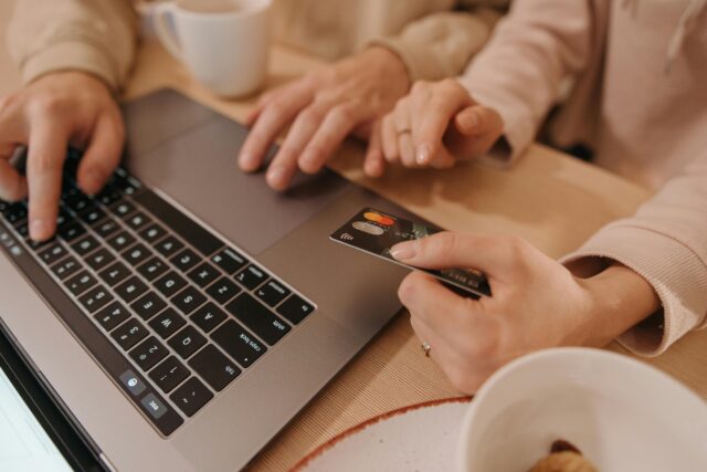 People checking something on a laptop with a credit card